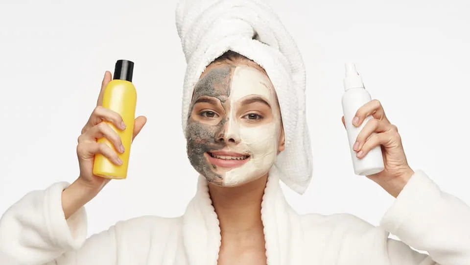 Skincare and self-care mood — woman in robe with skincare products