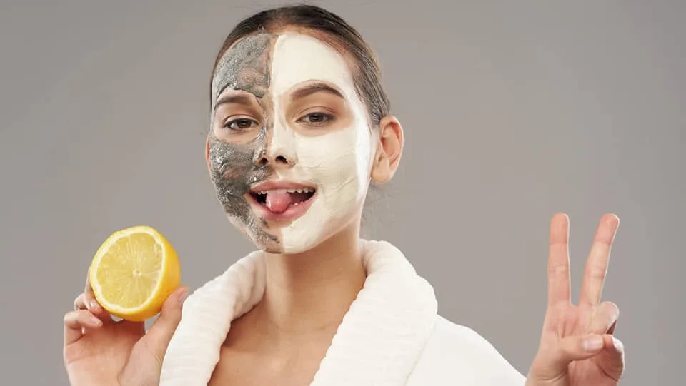 Playful skincare mood — a half clay mask and a lemon, grey studio
