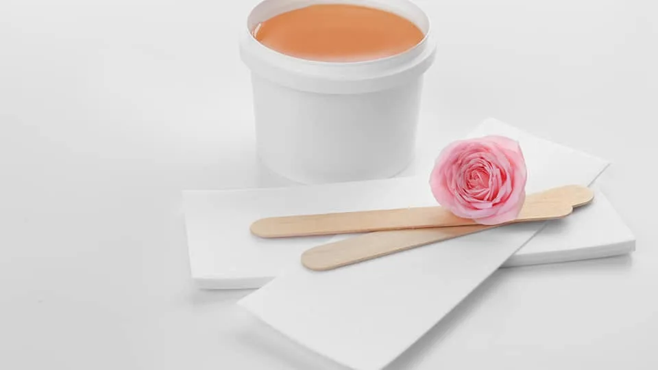 Waxing craft — warm wax pot and wooden spatulas, the essentials of a Bewaxxxed treatment
