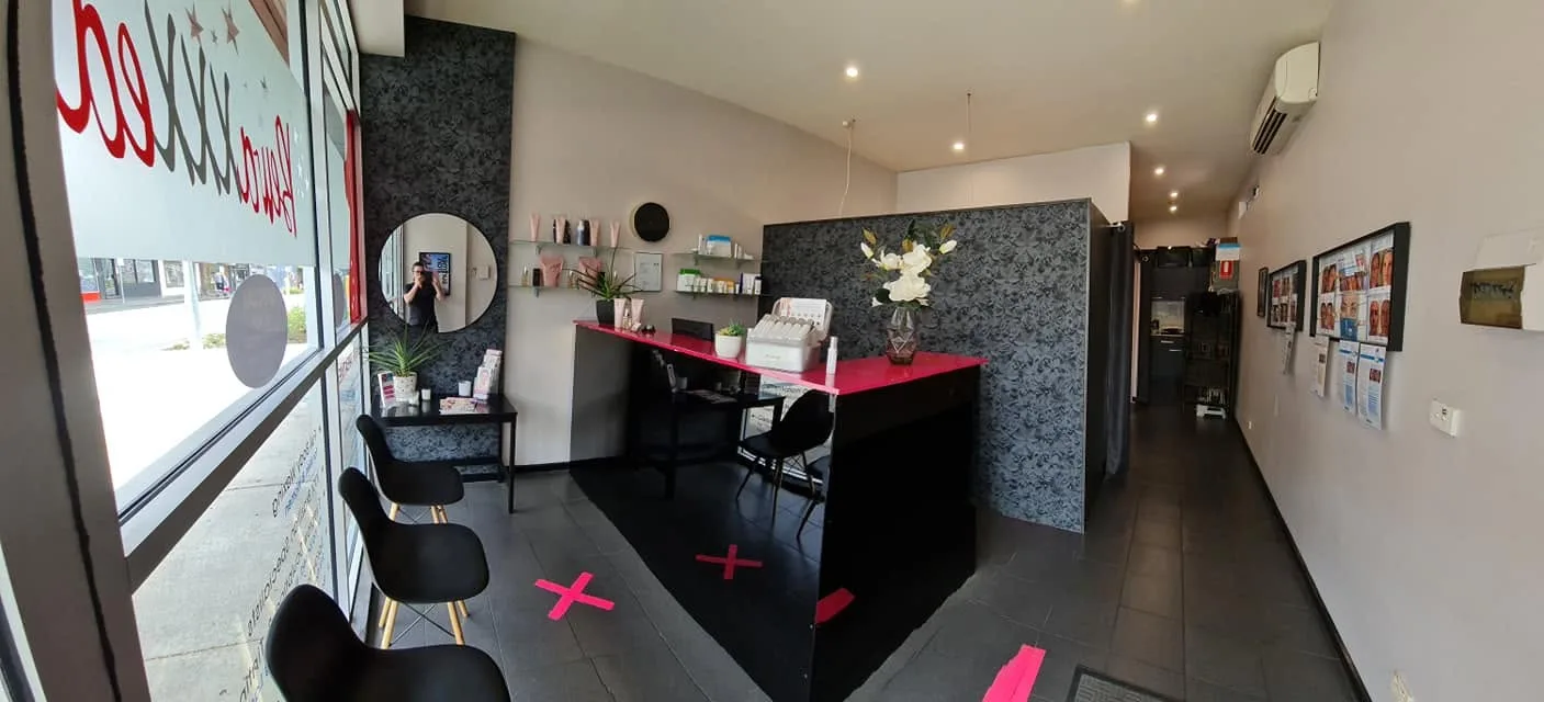 The Bewaxxxed reception — hot-magenta counter, charcoal floral-damask walls and boutique interior