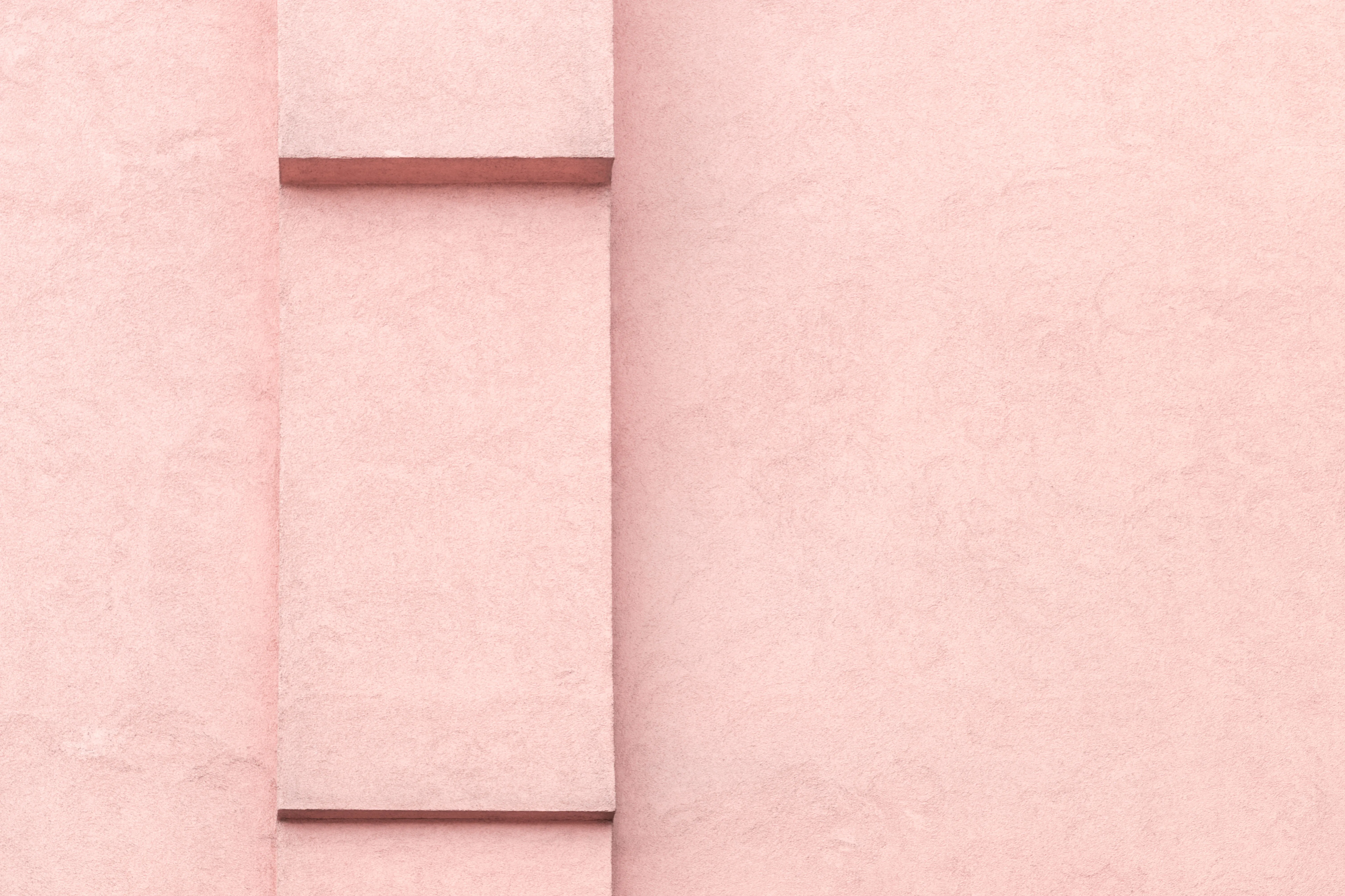 Blush rendered stucco wall with architectural relief — decorative background